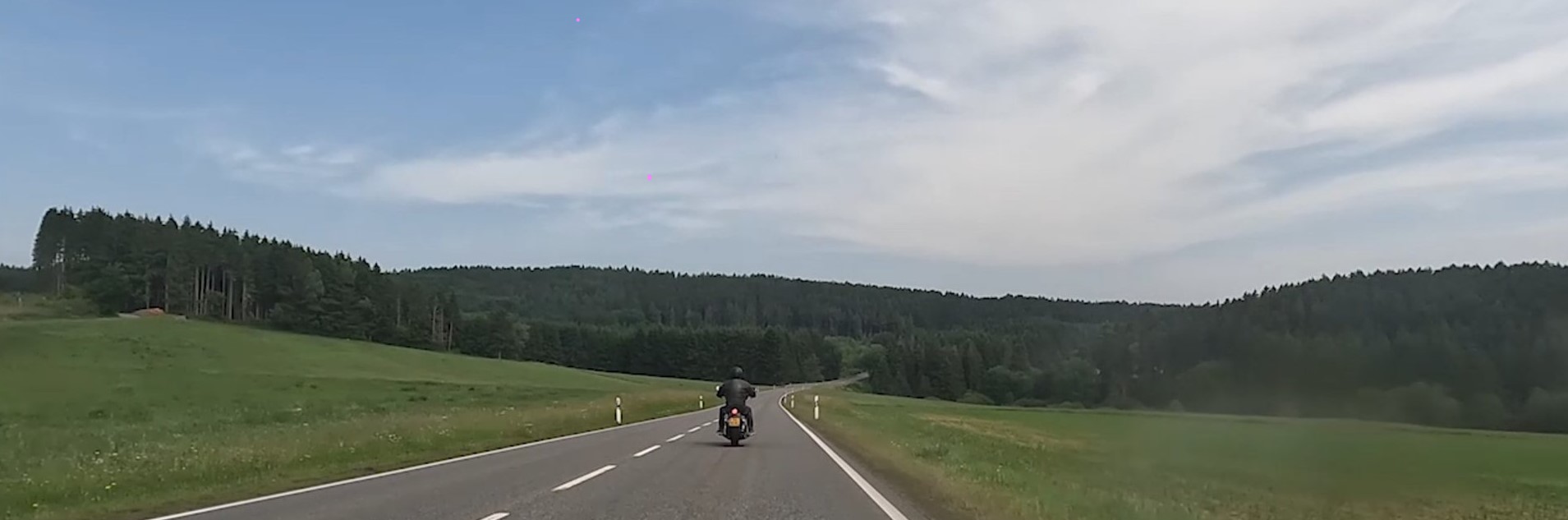 Uitzicht over een landweg door groene heuvels