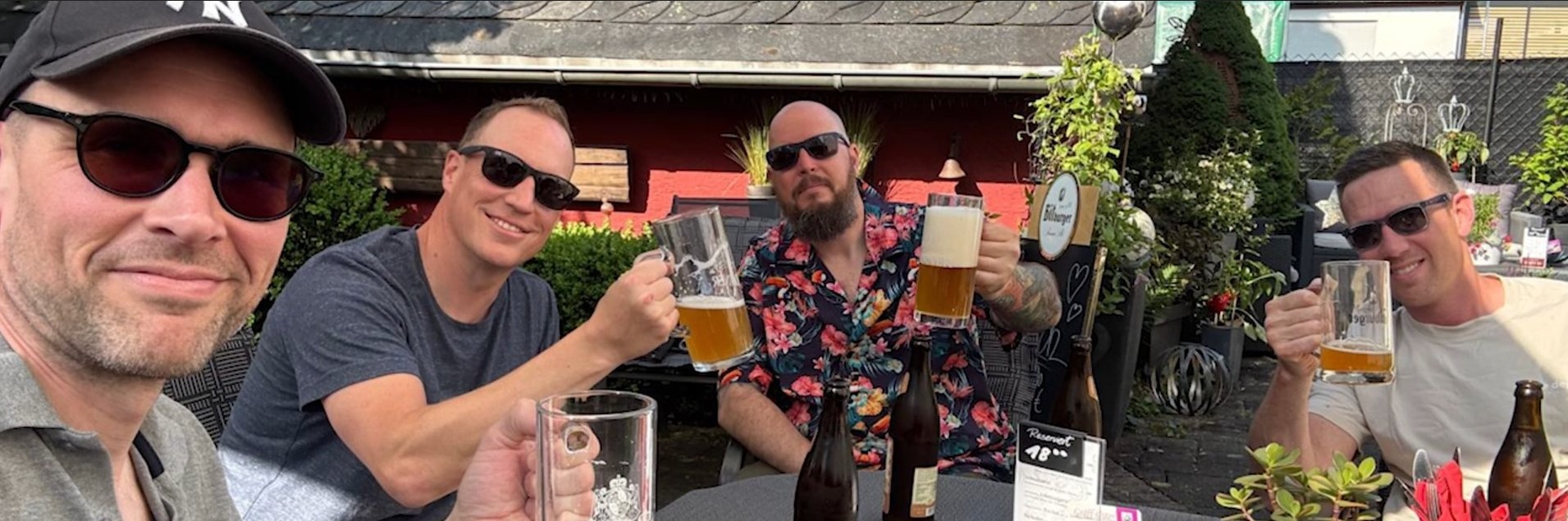 Groep rijders proost met een biertje op een terras